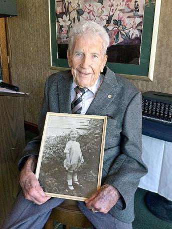 A photo of Robert Logsdon Jr. holding a photo.