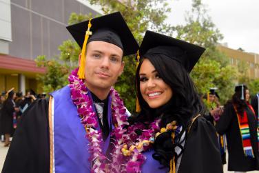 A photo of Spencer in graduation gown with his partner.