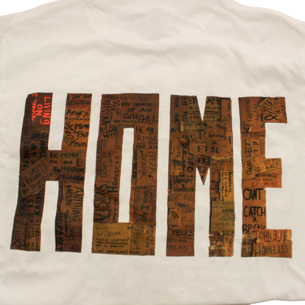 Back of a Gresham Gallery shirt word "HOME" made out of homeless people's cardboard signs