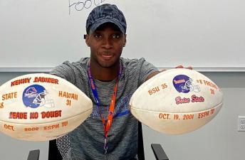 A photo of Jalen Neal holding two footballs.