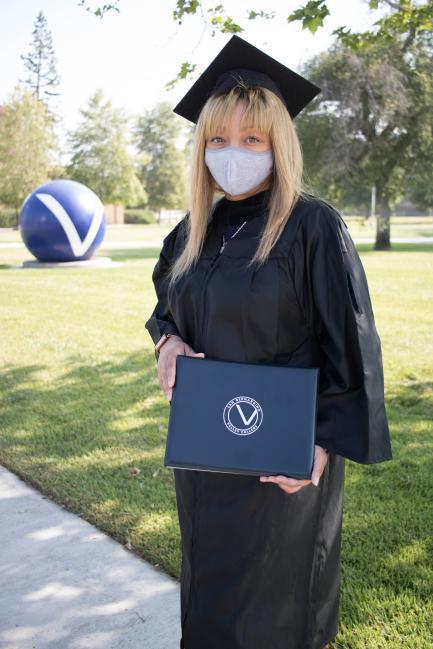 A photo of LaToya Pleasant in a graduation gown with her degree.
