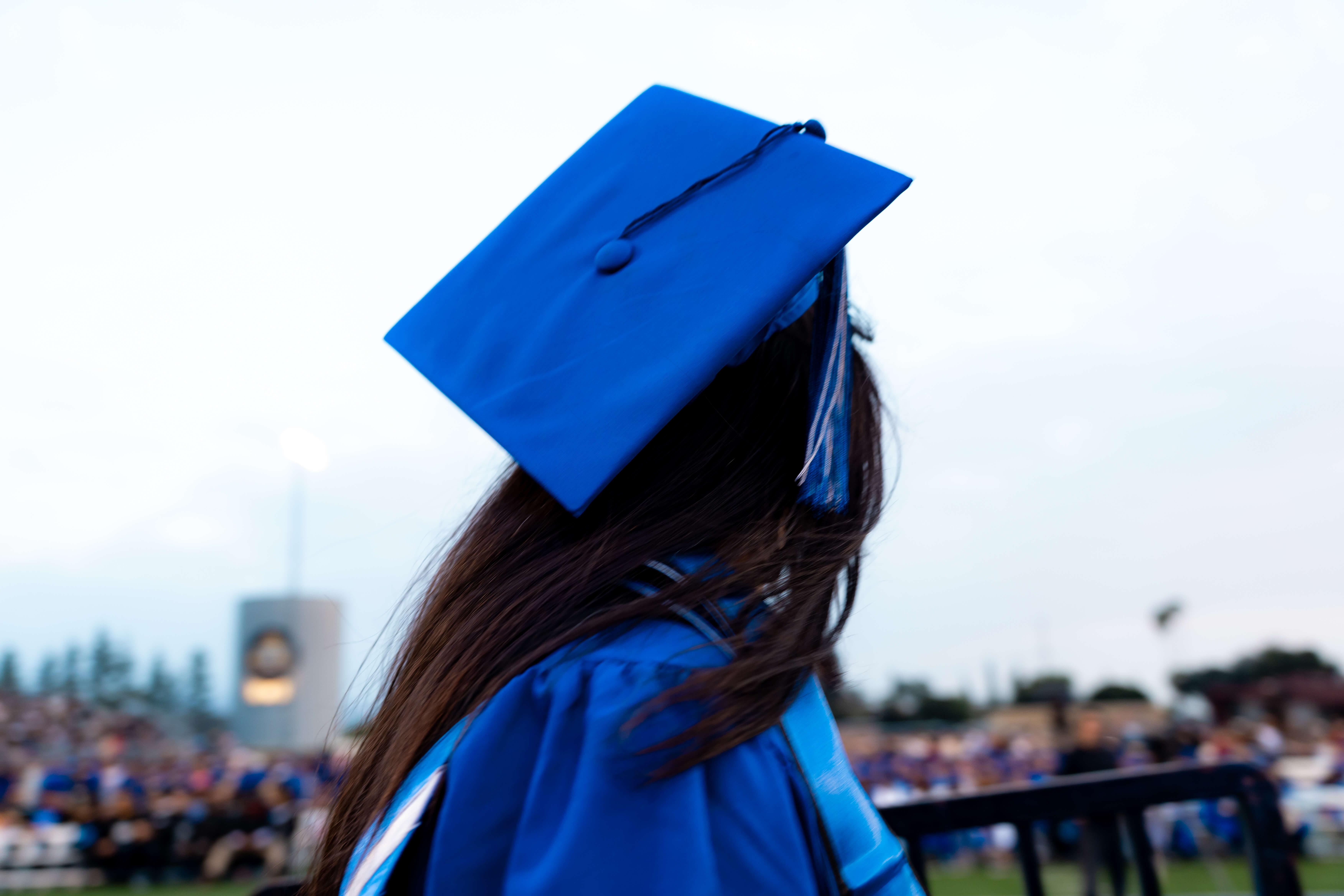 A graduate holds a diploma up in the air