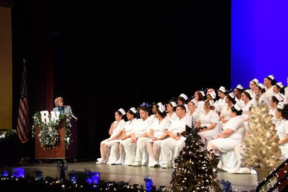 Dean Susan Bangasser congratulates graduates onstage.
