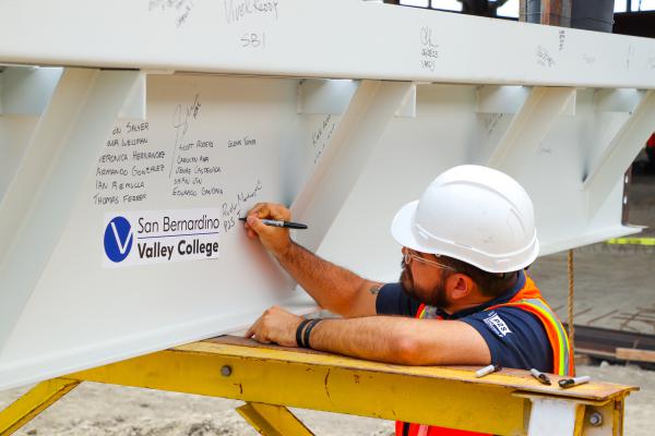 A construction worker signing the final beam