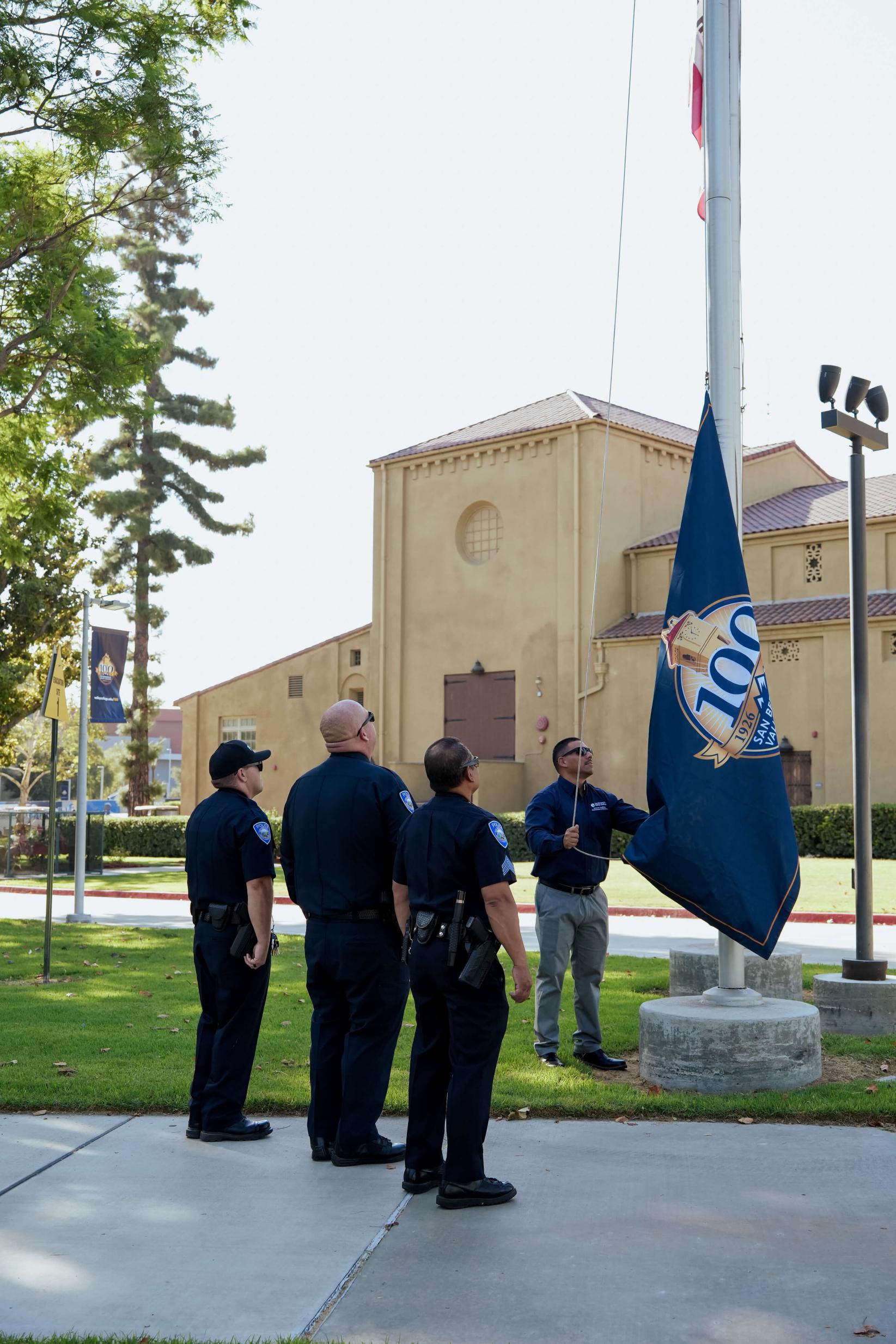 SBCCD Police raising the Centennial flag