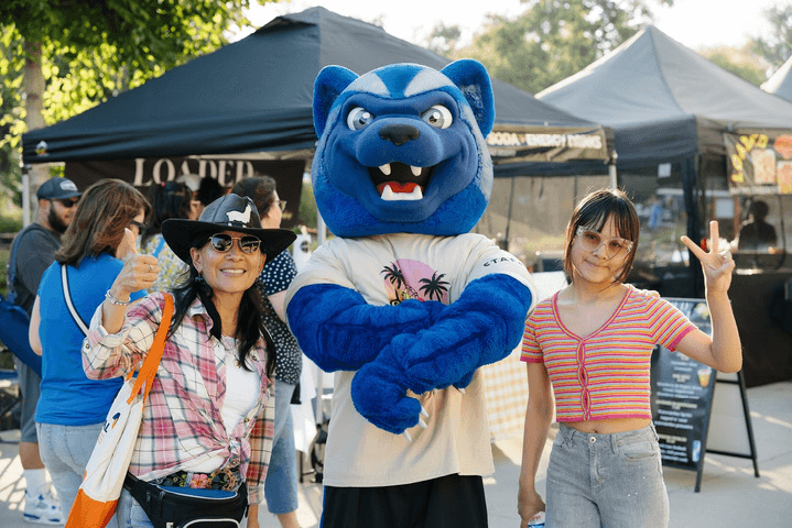 A mother and daughter pose with Blue during Summerfest