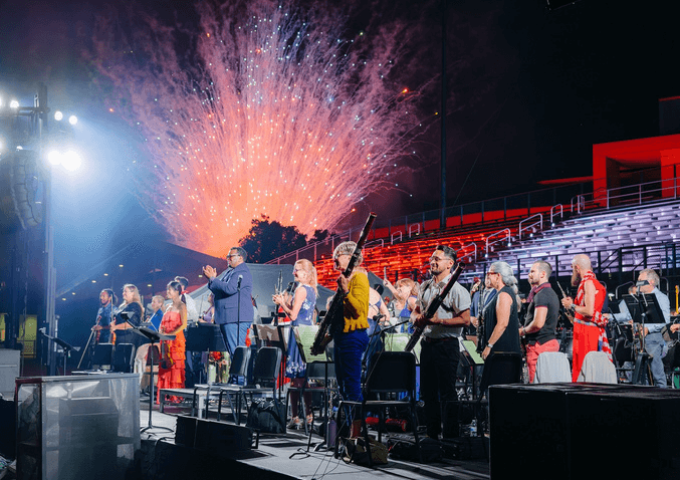 San Bernardino orchestra standing to a backdrop of fireworks