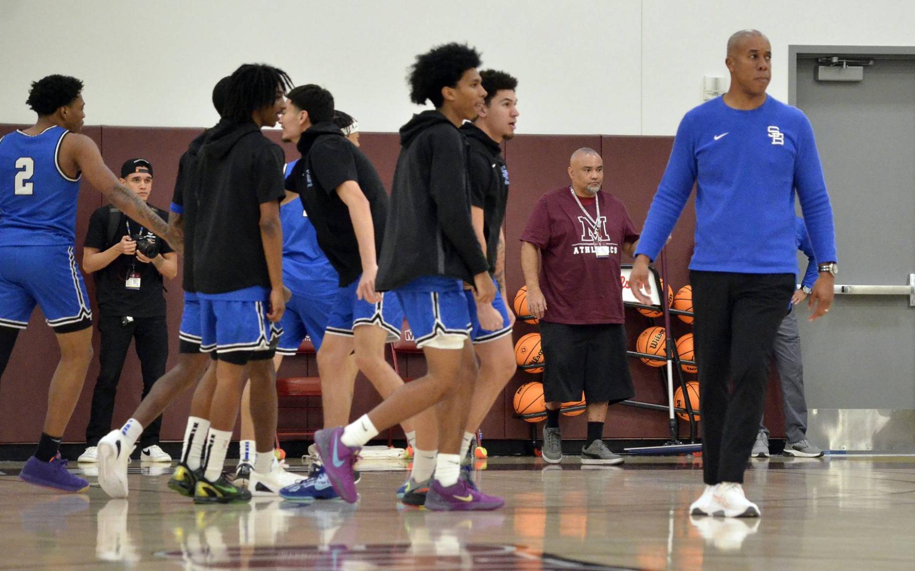 Coach Quincy Brewer on the court with players