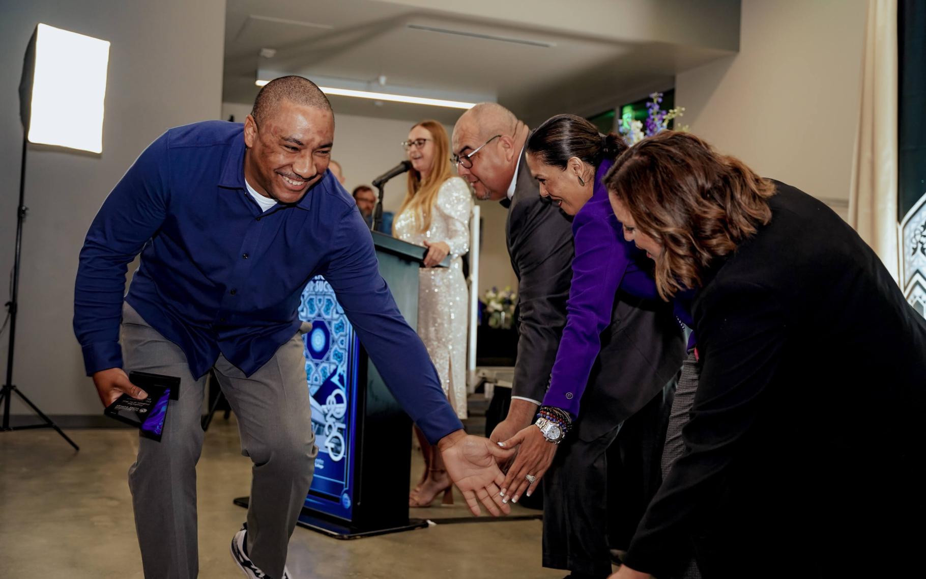 A spotlighting winner highfiving administrators