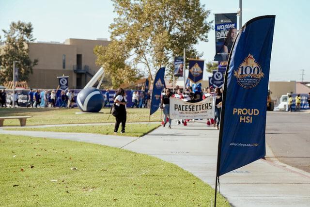 A banner on SBVC campus with the Centennial logo and saying "Proud HSI"