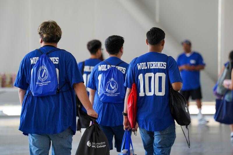 The backs of SBVC students walking together with jerseys that say "Wolverines 100" 
