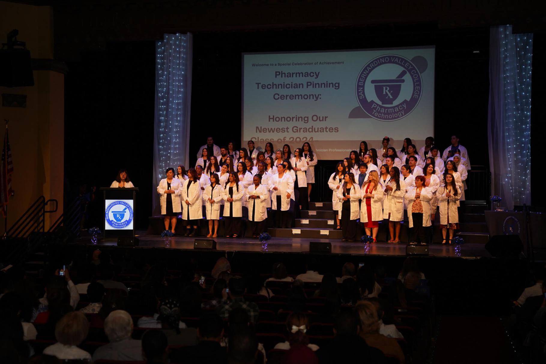 Pharmacy Tech students at their graduation stading on stage