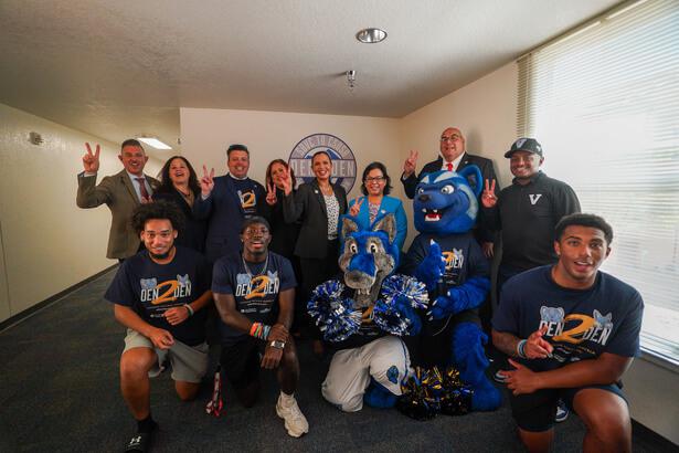 Students with SBVC faculty posing with Blue the Wolverine and CSUSB mascot