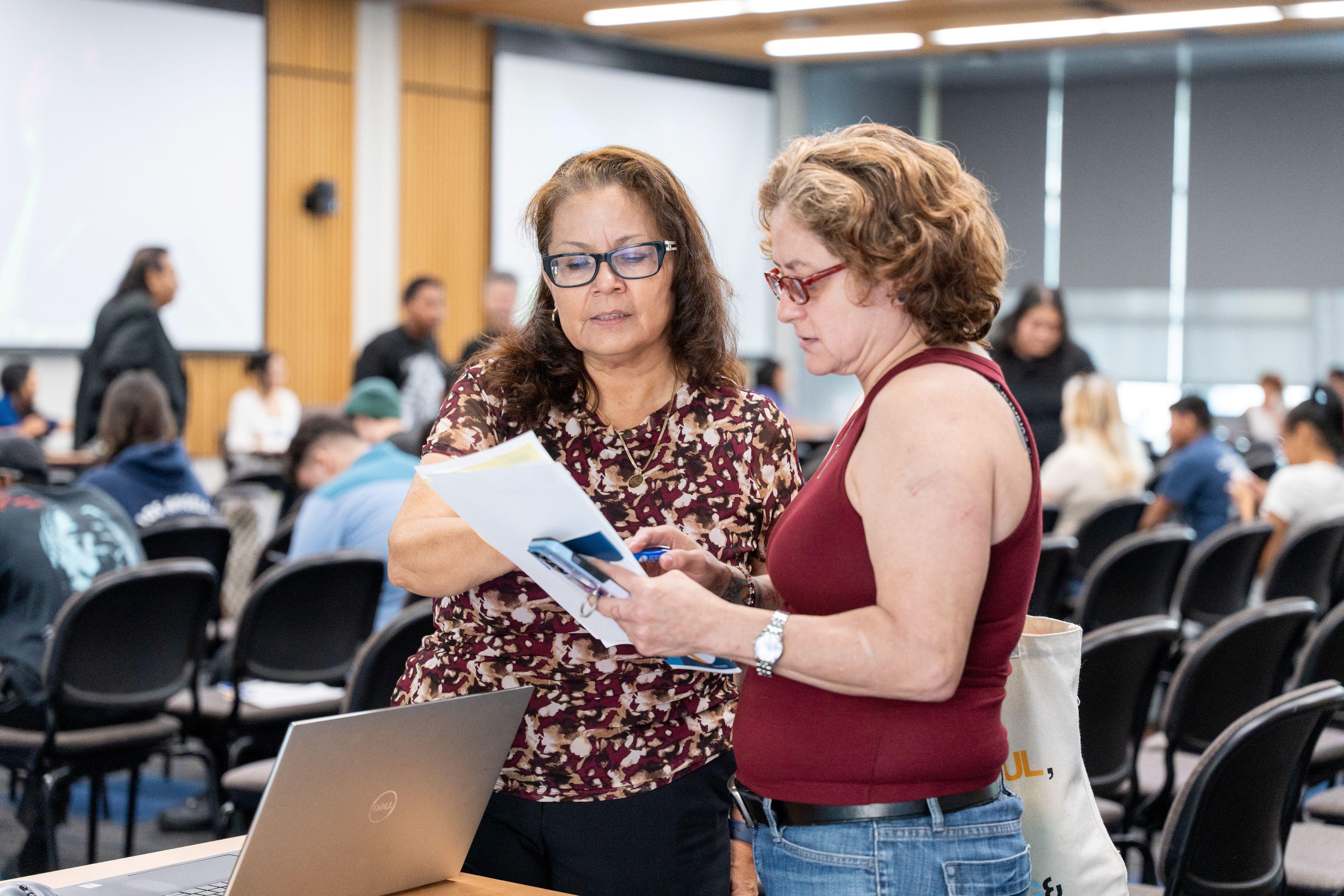 Woman helps student at campus event