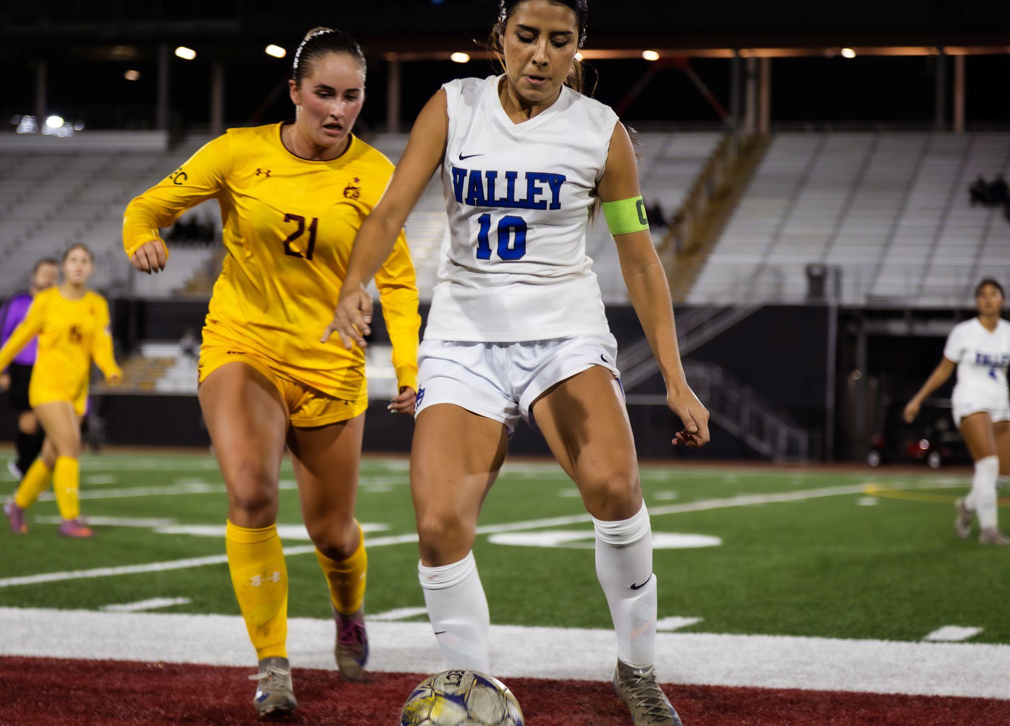 Two student athletes playing soccer