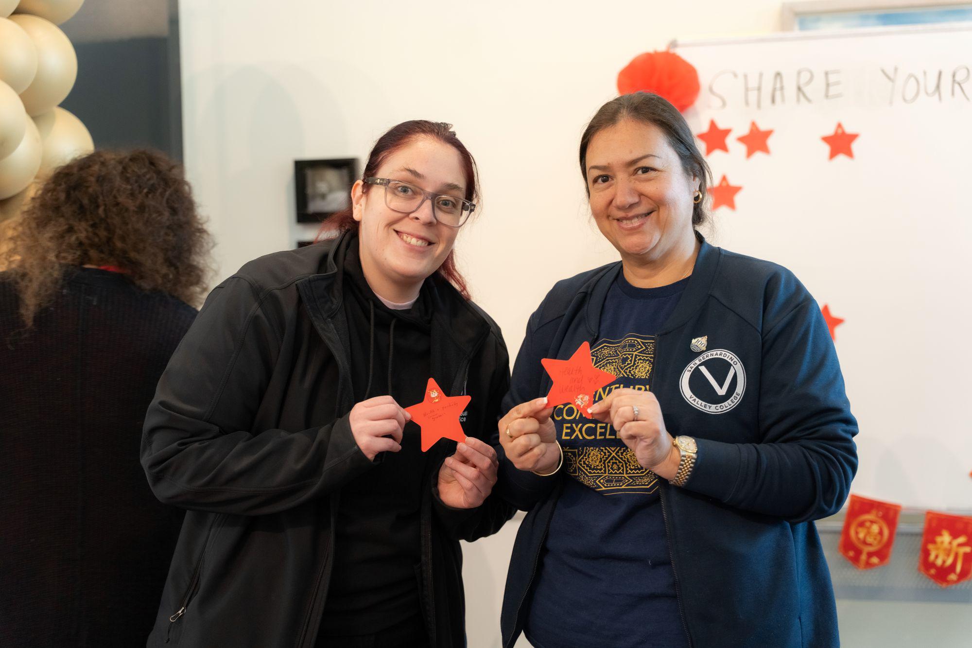 Two women hold a star craft