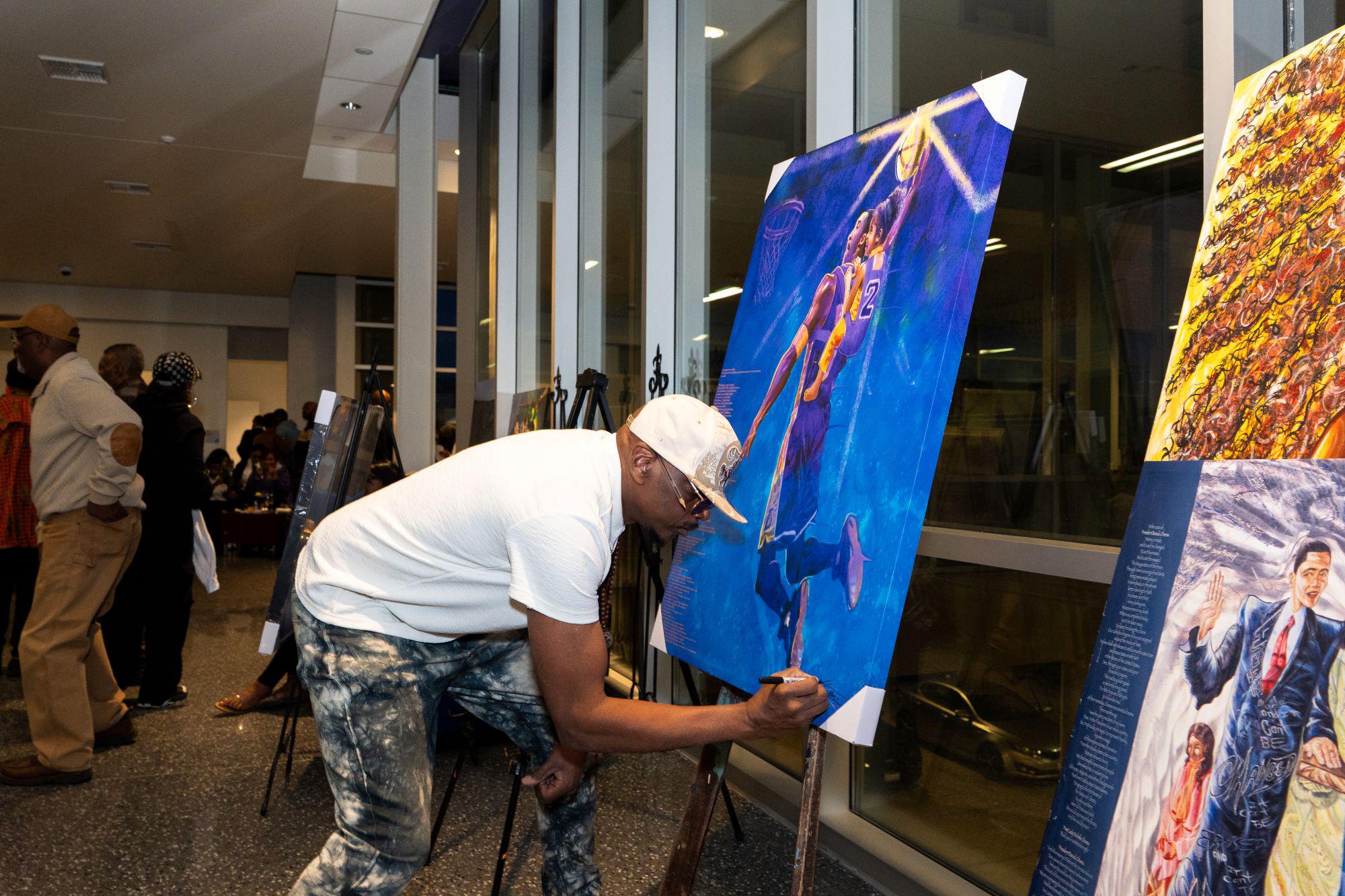 Man Signs Painting at Art Expo