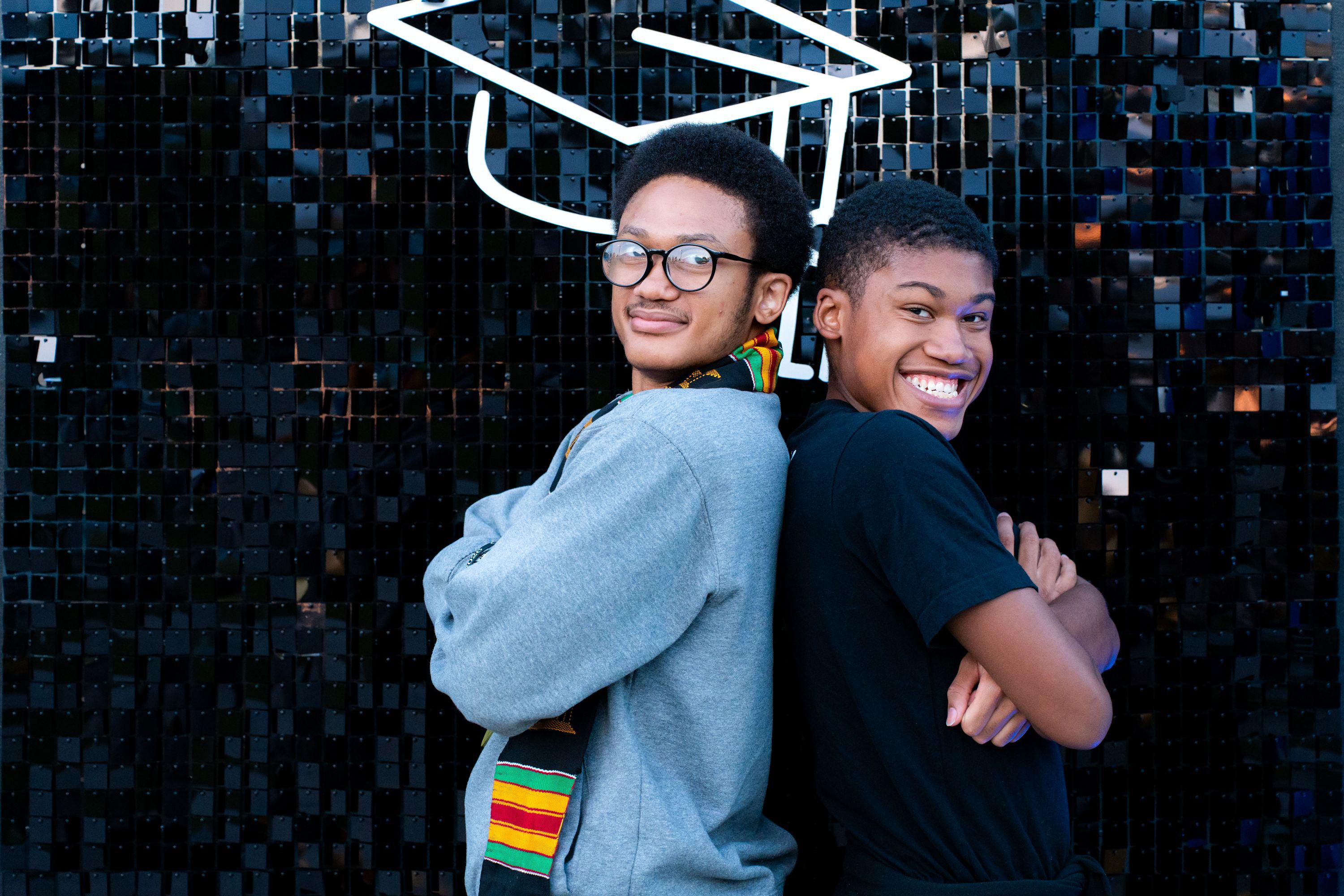Two male students pose back to back at Black Grad