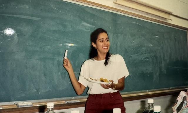 Young woman teaches in front of a blackboard