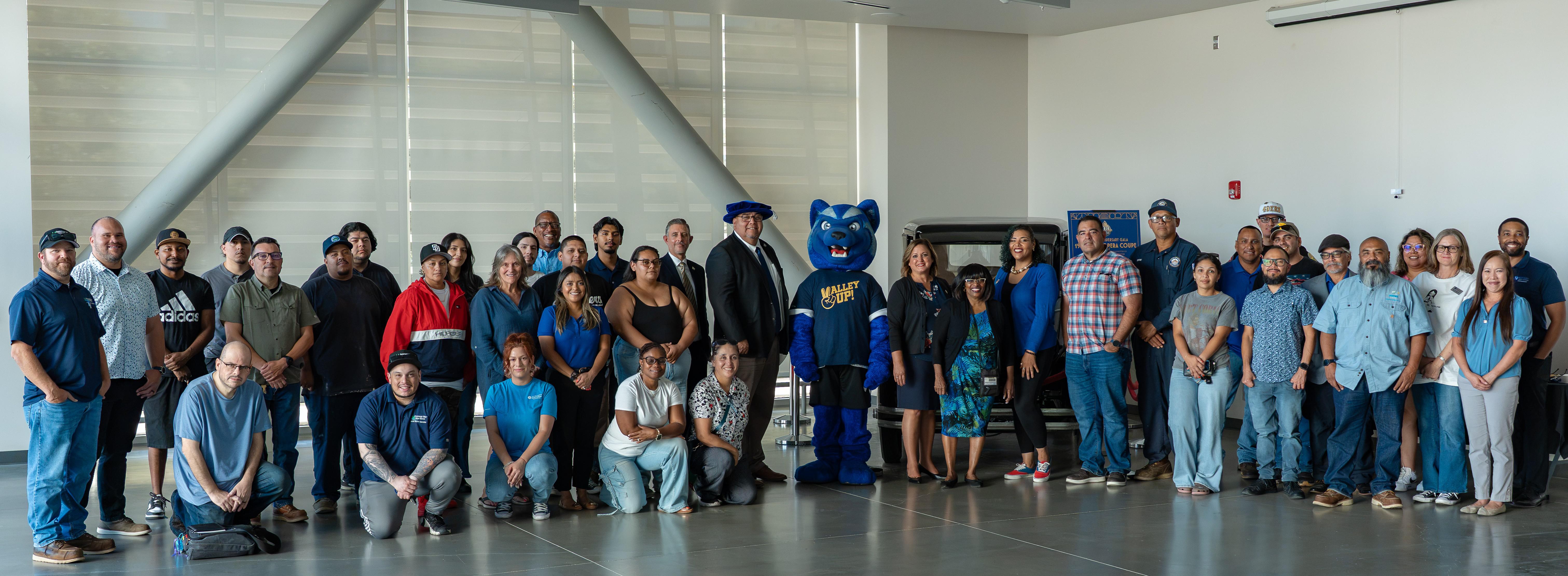 A large group of people stand with SBVC mascot Blue in the middle