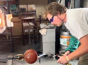 Man shapes molten glass