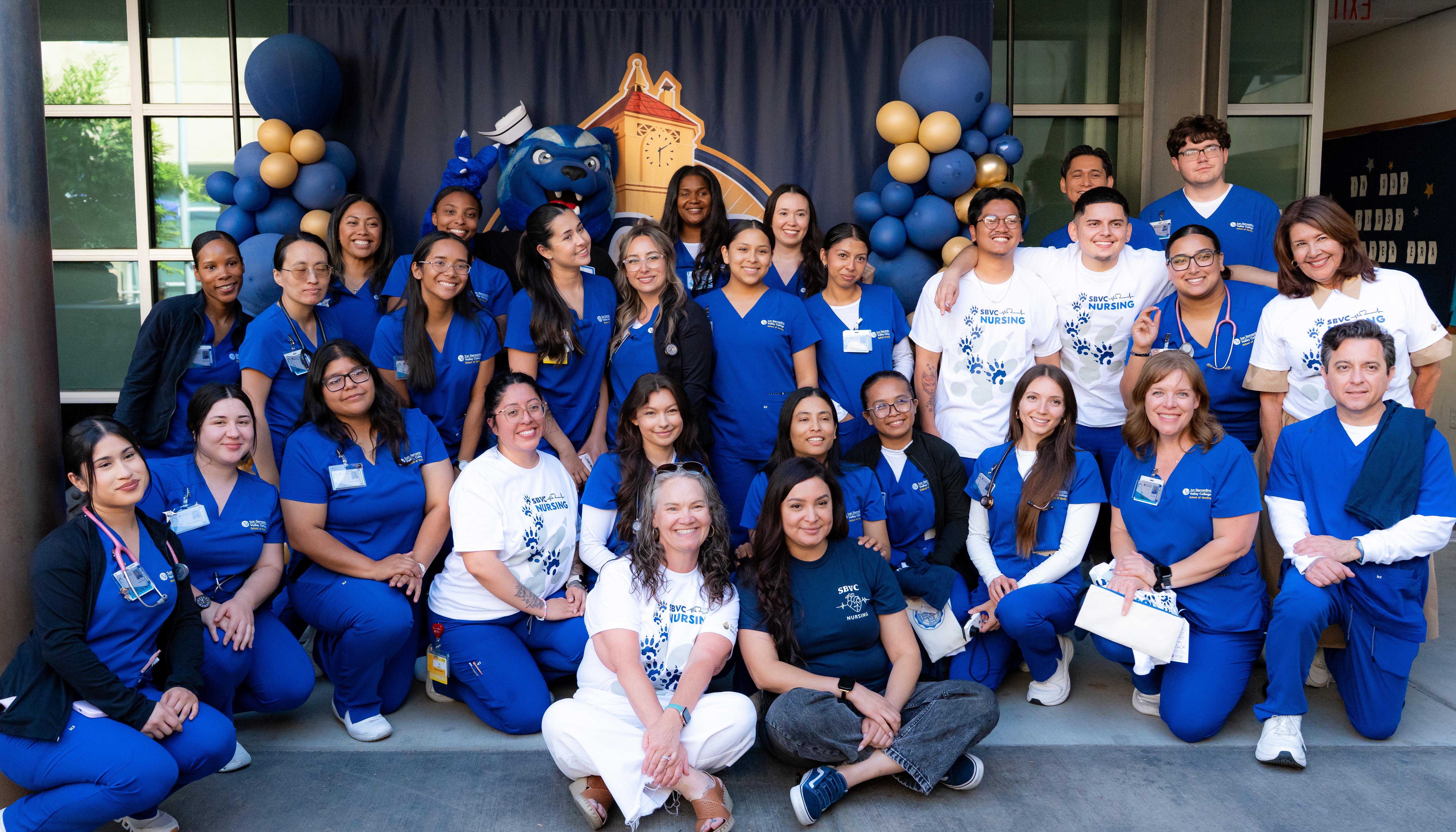 A large group of nursing students and nursing faculty members pose with SBVC mascot Blue
