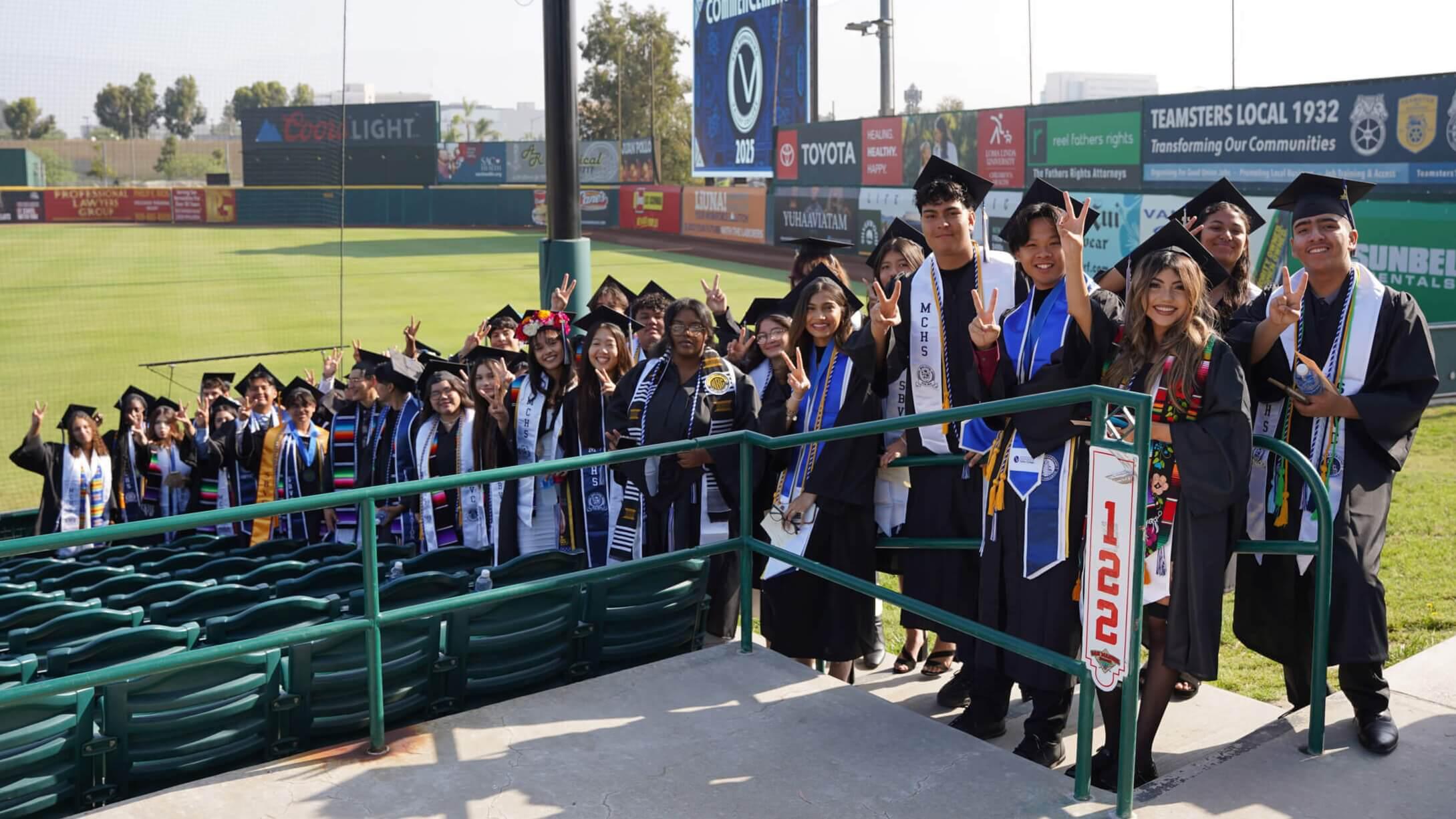 Graduates flashing the "Valley Up" symbol
